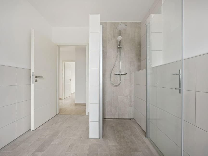 Bathroom with walk-in shower, white wall tiles and grey floor tiles