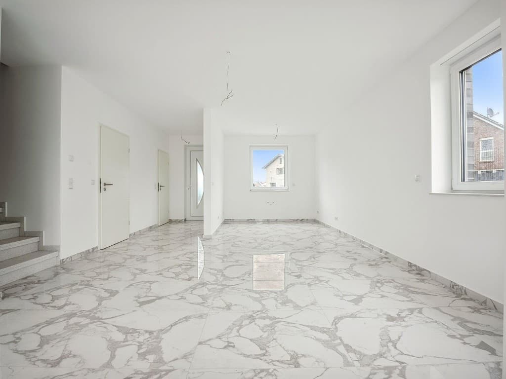 Bright empty room with large white marble-effect floor tiles and white walls